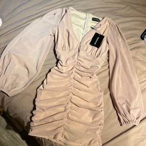  Nude mini dress PrettyLittleThing - Finaste nude klänningen med rkt smickrande passform 🥹 bara använd en gång. Har seamlessly sytt upp v-ringning med några cm som ni ser på sista bilden. Om man gillar att ha öppen o djupare v-ringning är de bara o sprätta upp då de bara några stygn 🥰