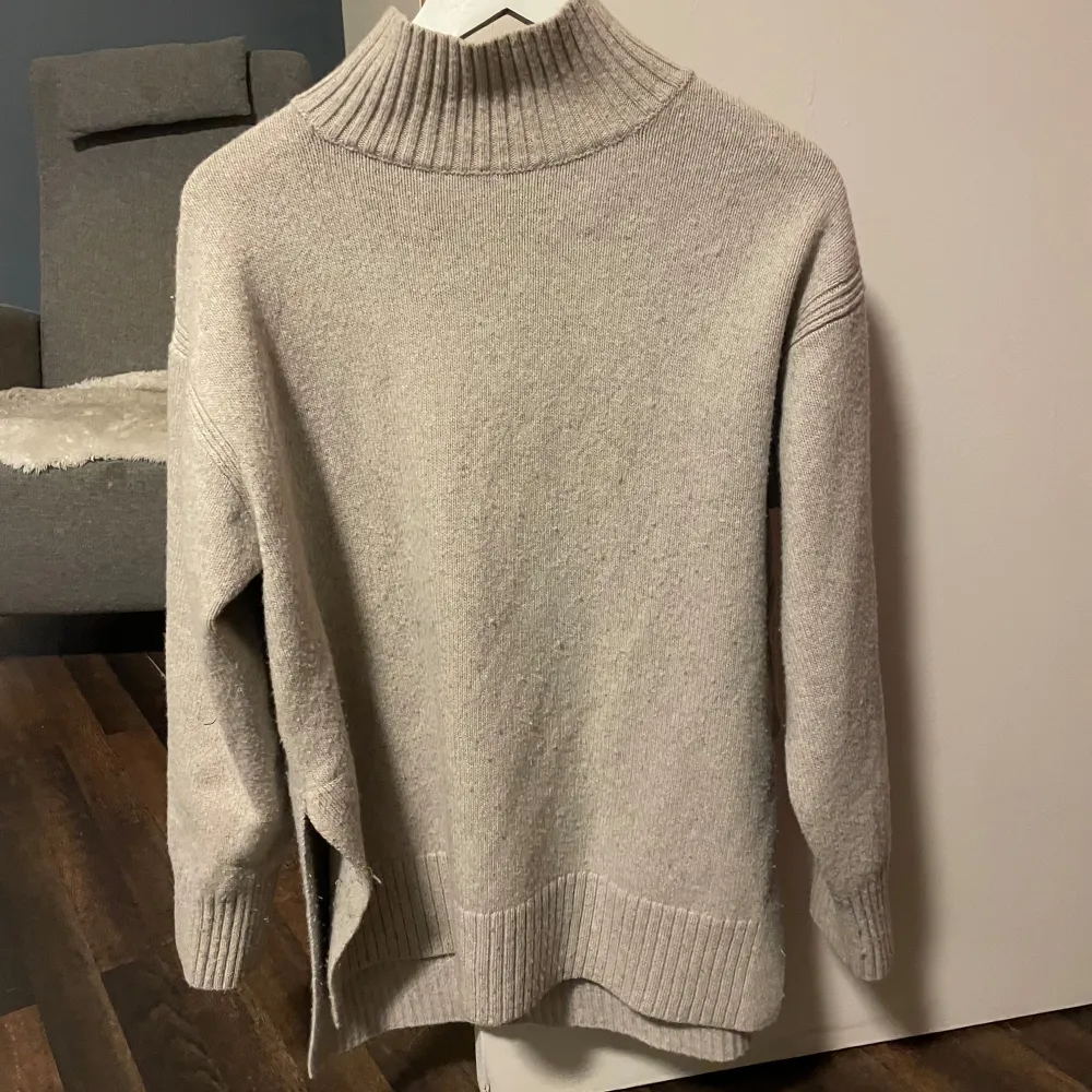 Mysig beige stickad polotröja med ribbade detaljer vid krage, ärmslut och nederkant. Perfekt för kyliga dagar. Skriv vid frågor🥰. Neuletakit & Villapaidat.