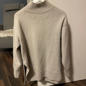 Beige stickad polotröja - Mysig beige stickad polotröja med ribbade detaljer vid krage, ärmslut och nederkant. Perfekt för kyliga dagar. Skriv vid frågor🥰