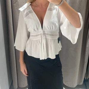 Vit blus från Zara - Säljer pga att den inte kommer till användning. Snygg vit blus med trekvartsärmar. Blusen har en v-ringad design och en lätt volangdetalj vid midjan.🌸 Perfekt för en stilren och chic look. Nypris 379kr från Zara. Använd några få gånger, inga defekter. 😊