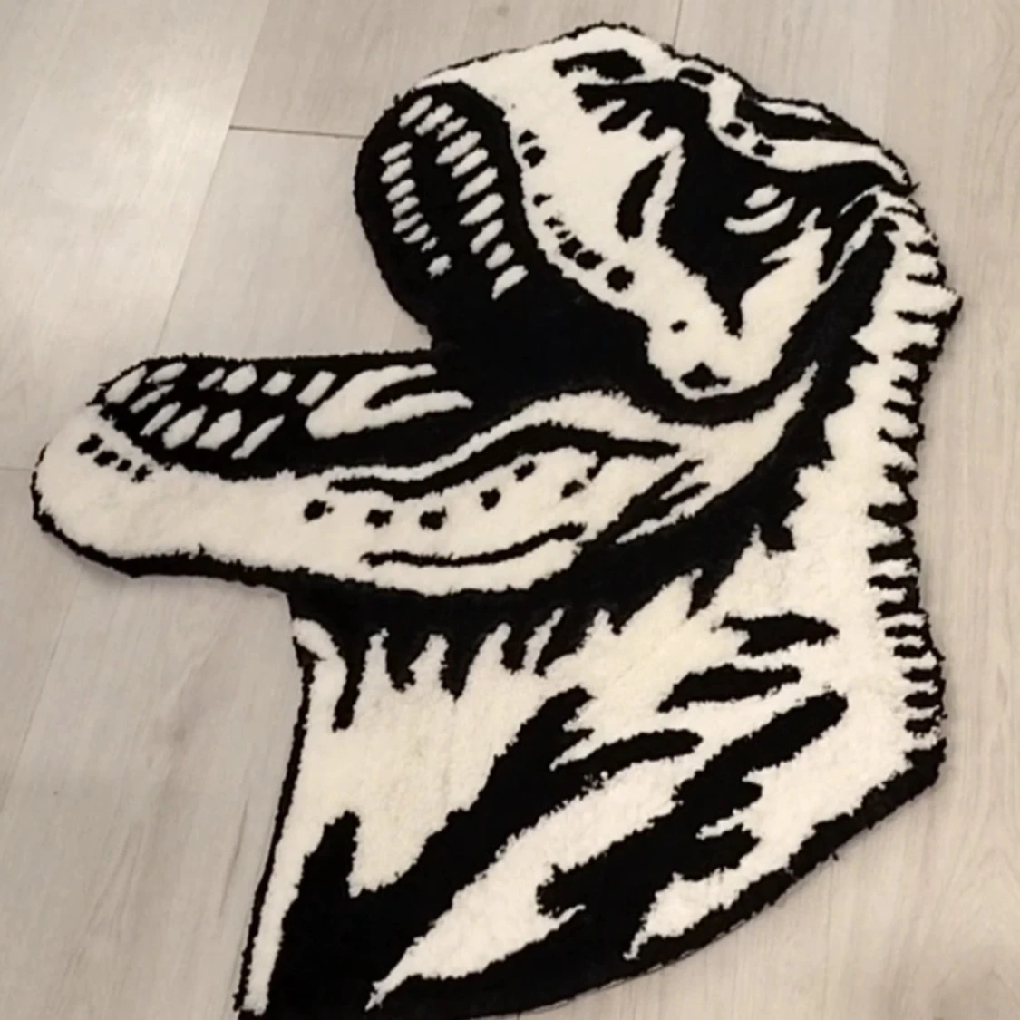 Svartvit matta med dinosauriemotiv