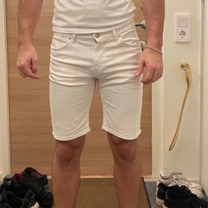 Vita shorts - Snygga vita shorts med normal passform och klassisk design. De har fem fickor och stängs med dragkedja och knapp. Perfekta för sommardagar.