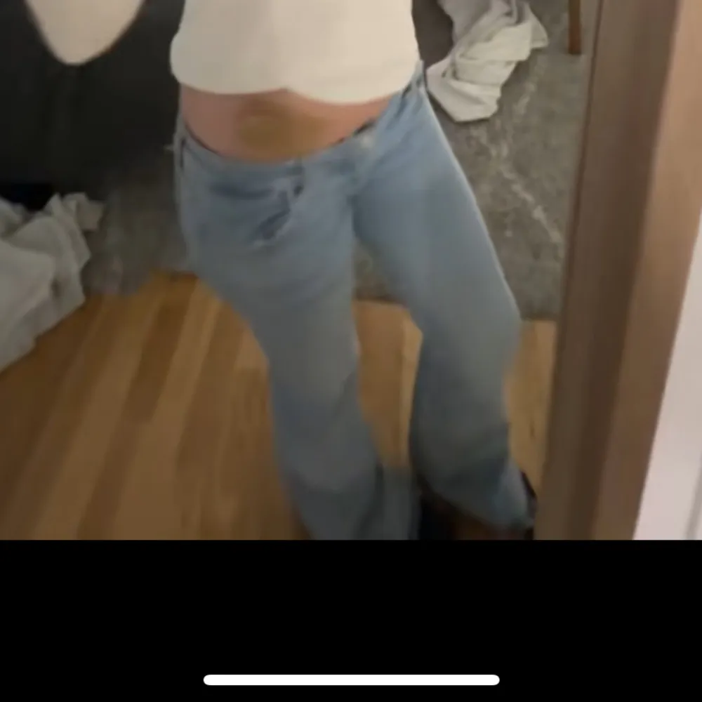 Säljer ett par ljusblå jeans med en avslappnad passform. De har en klassisk design med fem fickor och knappgylf. Perfekta för en casual look.. Farkut & Housut.