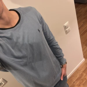 Blå tröja från Ralph Lauren - Säljer en stilren blå tröja från Ralph Lauren. Har tyvärr litet hål vid ärmen och liten fläck längst ner. Inget som märks super mycket men därav de billiga priset!