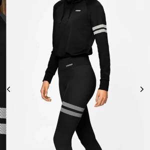 Svart hoodie och byxor från Stronger - Säljer en svart hoodie och matchande byxor från Stronger. Hoodien är kroppad, har en justerbar huva och vita ränder på ärmarna. Byxorna är högmidjade och har vita ränder vid benen. Båda är i storlek S. De är använda få gånger och i bra skick. Kontakta för fler bilder och information❣️