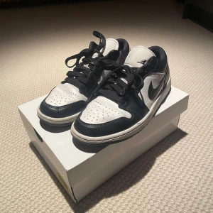 Nike Air Jordans i svart och vitt (använda fast som nya) - Snygga Nike Air Jordans i klassisk svart och vit färgkombination. Skorna har en ikonisk design med snörning och den välkända Nike-loggan på sidan. Perfekta för dig som vill ha en stilren look. De är använda endast 2 gånger men är som nya. 