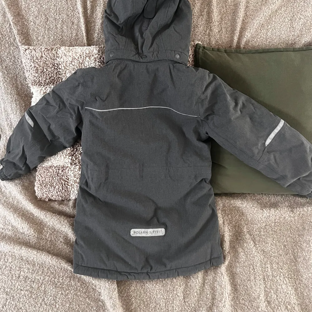 Vinterjacka från Polarn och pyret. Stl 128. Grå. Hängöglan behöver sys fast annars är jackan i fint skick. 400 kr. Takit.