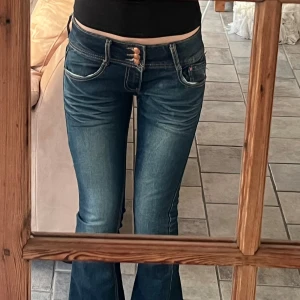 Lågmidjade utsvängda jeans - Jätte snygga vintage jeans med tre knappar! Lågmidjade bootcut och sitter som en Xs men passar S också då det står på lappen! Kom privat för frågor eller mått🥰
