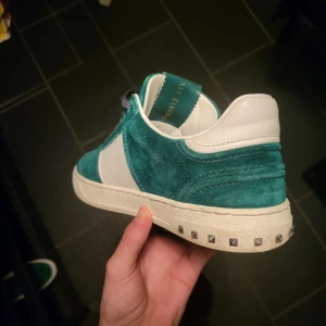 Flycrew byte! - Snygga gröna sneakers i mocka med vita detaljer och nitar på sulan från märket valentino, varken produceras eller säljs i butik längre! Tar gärna byten mot mörk blå gats i 42