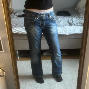 Blå jeans från True Religion - Snygga blå jeans från True Religion med kontrastsömmar och klassisk femficksdesign. De har en låg midja och ganska baggy dom är i storlek 32 och passar M
