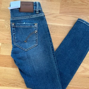 Nya blå jeans från Dondup - Snygga blå jeans från Dondup perfekt för en stilren look. De har original lappen kvar. Tillverkade i Italien. Priset är inte fastslaget i sten. Fraktar helst med PostNord 