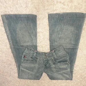 Lågmidjade jeans med bootcut - Super snygga Ravel blåa jeans med bootcut (nästan flared) och som går in efter kroppen för uppmärksamma en smallmidja och större höfter. Säljer dessa jeans som jag köpte på Plick, men som inte passade mig då de var för små. De har en femficksdesign och dubbla knappar i midjan. Perfekta för en avslappnad stil med en touch av retro☺️ (PS, de två första bilder är inte mina) 