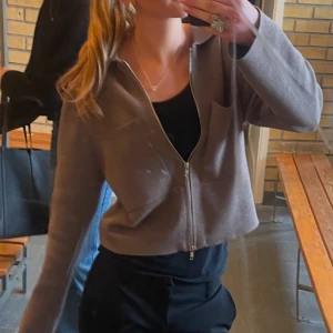 Kofta från Åhléns! - Säljer en stilren beige jacka från Åhléns  i storlek XS. Jackan har en dragkedja framtill och långa ärmar. Perfekt för en avslappnad look. 🧥Inga defekter nypris 600kr! 