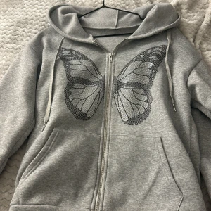 Grå hoodie med fjärilsdesign - Säljer denna för den inte kommer till användning. Har använt den 1 gång och den är från new yorker. Den är i storlek xs 