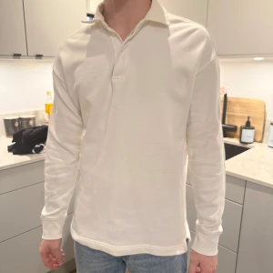 Vit långärmad pikétröja - Säljer en stilren vit långärmad pikétröja med klassisk krage från H&M. 