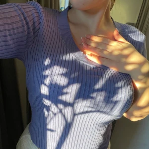 Lila ribbad tröja - Säljer en stilren lila ribbad tröja med långärmad design. Perfekt för en chic och bekväm look. Passar bra till både jeans och kjol.