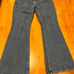 Blå jeans från Tommy Hilfiger  - Säljer ett par snygga blå jeans från Tommy Hilfiger. De har en bred bootcut-stil och är tillverkade i slitstarkt denim. Använda men i jättebra skick!
