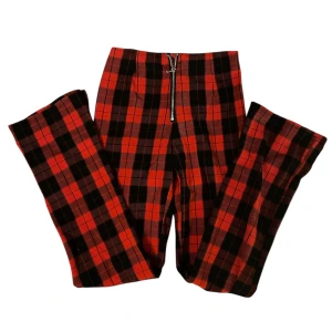 Rutiga leggings - Leggings med dragkedja fram med utsvänga ben. Inga fel så förutom att en sömn har gått upp där framme men inget som påverkar jättemycket