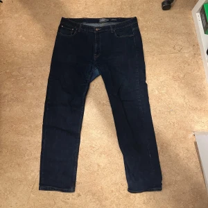 Mörkblå jeans från Dressmann - Säljer ett par mörkblå jeans från Dressmann i klassisk stil. De har en normal passform med fem fickor och knappgylf. Perfekta för en avslappnad look.