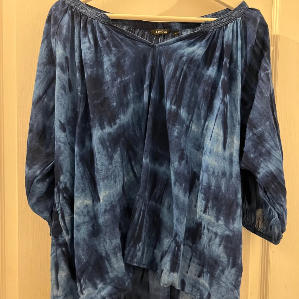 Säljer en blå batikmönstrad blus från Lindex. Blusen har en lös passform med trekvartsärmar och en bekväm, avslappnad stil. Perfekt för en bohemisk look.. Yläosat.