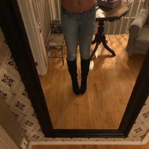 Blå jeans med hög midja - Snygga blå jeans med hög midja och en tight passform. Perfekta för en stilren look. De har klassisk design med dragkedja och knappar framtill.