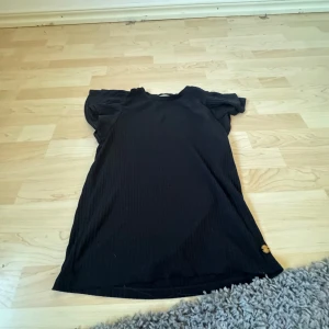 Svart topp från Pernilla Wahlgren - Säljer en stilren svart topp från Stella Wahlgren. Toppen har korta ärmar och en enkel design som passar perfekt till olika tillfällen. Den är tillverkad i ett mjukt material som ger en bekväm passform.