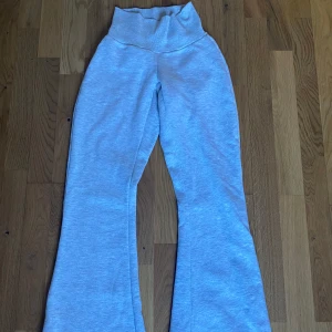 Grå mjukisbyxor från Gina Tricot - Säljer ett par bekväma grå mjukisbyxor från Gina Tricot. Byxorna har en låg midja och en bootcut-stil som ger en avslappnad look. Perfekta för en mysig dag hemma eller en avslappnad utflykt.
