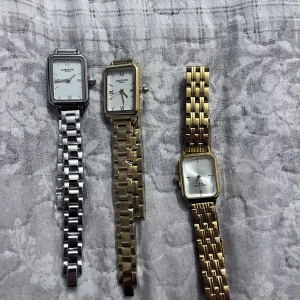 Klassiska klockor från Lorenzo - Säljer tre eleganta klockor från Lorenzo. Två i guld och en i silver, alla med rektangulära urtavlor och romerska siffror. Perfekta för en stilren look. Armbanden är i metall och har en klassisk länkdesign.