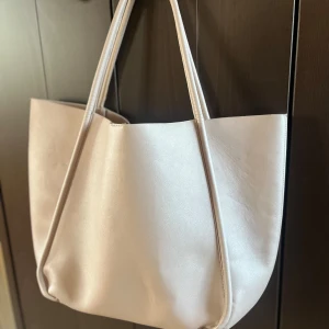 Beige axelväska - Snygg beige skolväska från New Yorker!🥰 Väskan har långa handtag och en praktisk stängning med hake inuti. Stort utrymme och i skinn material. Knappt använd 💕