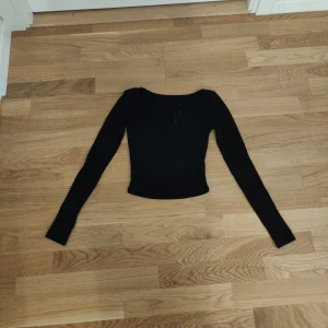 Svart långärmad topp - Snygg svart långärmad croptopp med knappar framtill. 