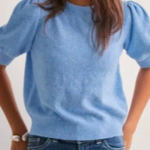 Blå stickad tröja Vero Moda - Säljer en söt blå stickad tröja med korta puffärmar. Perfekt för en avslappnad stil och kan enkelt matchas med jeans. Tröjan har en rund halsringning och ribbade kanter.