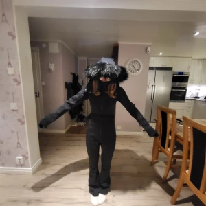 Svart skidoverall från Asos - Säljer en svart skidoverall från ASOS med pälskantad huva, skärp,  utsvängda ben. . Overallen har en tight passform och är perfekt för vintersport. Den är designad för att hålla dig varm och bekväm i backen. Perfekt för dig som älskar att åka skidor eller snowboard! ❄️ Ej använd. Ordinarie pris 1859kr.