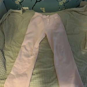 Rosa mjukisbyxor med snörning - Säljer ett par bekväma rosa mjukisbyxor med snörning i midjan. Perfekta för en avslappnad dag hemma eller en promenad i parken. Byxorna har en loose passform och är gjorda i mjukt material för extra komfort.