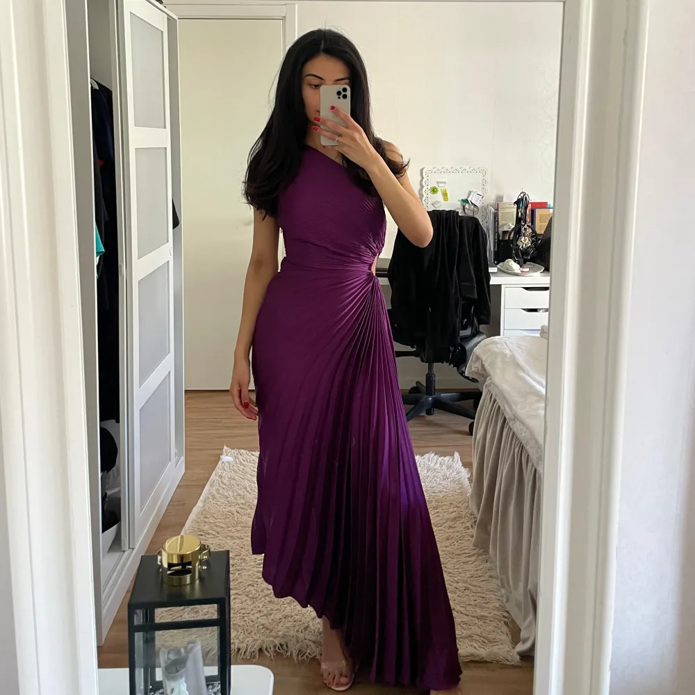 Aldrig använd, bara provat klänningen! Storlek S, men passar även XS. Perfekt för bröllop eller fest Skicka gärna prisförslag eller köp nu knappen. Elegant lila långklänning med oneshoulder-design och plisserad detalj. Perfekt för en glamorös kväll med sin flytande siluett och unika stil. Klänningen har en smickrande passform som framhäver figuren.. Mekot.