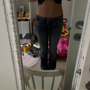 Mörkblå jeans med slitningar Ltb - Snygga mörkblå jeans med en tight passform och diskreta slitningar på låren. De har en klassisk femficksdesign och är lågmidjade. Perfekta för en casual look.