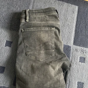 Grå jeans med slim straight fit 30/32 - Snygga grå jeans med en slim straight passform. De har en klassisk femficksdesign och en subtil tvättad look. Perfekta för en stilren vardagslook. Bra skick och är storlek 30/32. 