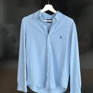 Ljusblå skjorta från Ralph Lauren - Snygg ljusblå skjorta i storlek S från Ralph Lauren i featherweight mesh. Skjortan är i nyskick och köptes in från NK för 1999. Bara att kontakta om du har frågor