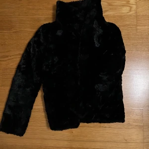 Svart pälsjacka från H&M - Säljer en snygg svart pälsjacka från H&M. Jackan har en mjuk och fluffig yta med långa ärmar och en klassisk krage som man kan ha upp och ner.🖤💯Den är storlek 158 men är bara lite för liten för mig som är 170cm🩷🙏🏻