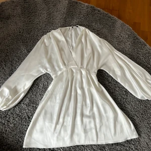Vit klänning  - Säljer dena fina siden klänning ifrån Gina tricot! Den är bara använd en gång och ör perfekt för student eller konfirmation! Den är i strl 34!