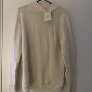Vit ulltröja från H&M - Säljer en stilren vit tröja från H&M i RWS-certifierad ull. Tröjan har en ribbad krage och långa ärmar, perfekt för kyligare dagar. Enkel och tidlös design som passar till det mesta. 🧶Prislappen kvar, aldrig använd!