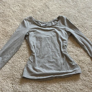 Grå långärmad topp från lager 157 - Säljer en stilren grå långärmad topp från lager 157 i storlek XS. Tillverkad i en mjuk blandning av bomull, viskos och elastan för en bekväm passform. Perfekt för en avslappnad look.