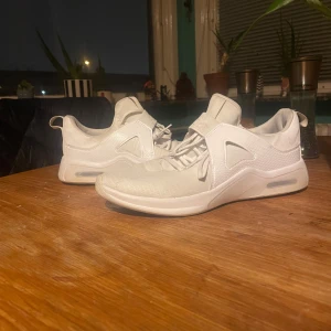 Vita sneakers från Nike - Säljer ett par vita Nike sneakers med snörning och en stilren design. Skorna har en synlig Air Max-sula för extra komfort och stil. Perfekta för en sportig look. Storlek: 41. Finns att mötas i Gbg annars står köparen för frakten. 