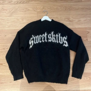 Svart tröja från Sweet SKTBS - Säljer en svart tröja från Sweet SKTBS med text i vitt på framsidan. Tröjan har långa ärmar och är gjord i ett mjukt material som ger en skön känsla. Perfekt för kyligare dagar. Det står att den är xxs men den är stor i storlek och passar bra om man är ca 175