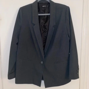 Mörkgrå Blazer Från Gina Tricot - Jag säljer nu denna mörkgrå blazer (rak modell) i strl 40 från Gina Tricot. Jag köpte denna på Vinted men den var tyvärr lite för liten för mig. Ser inte ut att vara så använd och den har en fin mörkgrå färg som som smälter bra in med tex svarta kostymbyxor. Väldigt fin blazer som gör en vanlig outfit uppklädd och värmer på lite kyligare kvällar! Skulle passa perfekt att ha nu på nyar eller andra event!💞