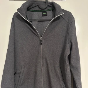 Grå jacka från Boss - Tja, säljer nu denna jätte snygga boss koftan/jackan som är helt ny andvönd 1-2 gånger endast! Den har inga defekter eller liknande. Nypris ligger runt 1800kr. Hör av er vid eventuella frågor.