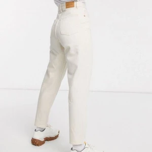 Vita jeansbyxor Taiki - Snygga vita jeansbyxor i 100% bomull. De har en klassisk design med hög midja och balloon leg.  Perfekta för en stilren look. Modellen är Taiki från Monki.