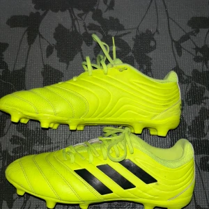 Copa fotbollsskor från Adidas - Säljer ett par copa fotbollsskor från Adidas med svarta ränder. Skorna har snörning och är designade för optimal prestanda på planen.
