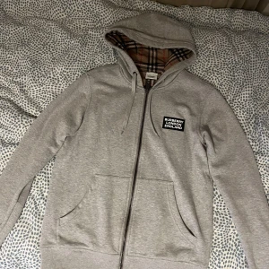 Burberry HOVE Check Hoodie Zip-up - Jag säljer min Burberry HOVE Check Hoodie Zip-up som jag köpte för 5400 SEK. Tröjan är nästan helt ny och har endast använts ett par gånger. Den är i toppskick utan några synliga skador eller slitage. Storlek: XS