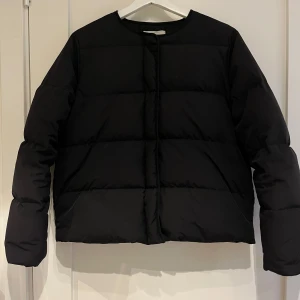 Svart pufferjacka från Samsøe Samsøe - Snygg svart pufferjacka från Samsøe Samsøe. Jackan har en stilren design med rund hals och långa ärmar. Perfekt för kyligare dagar. Finns en liten fläck som man kan se på bild 3, tror den går bort i tvätten. Men Annas inget man lägger märke till 🥰