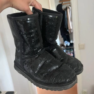 Svarta paljettstövlar från UGG - Snygga svarta UGGs med paljetter. Tecken på användning men ändå väldigt fina. Storlek 39 men passar 38-40 